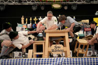 Men dressed in traditional clothes try to pull the opponent over the table at the German Championships in Fingerhakeln or finger wrestling, in Bernbeuren, Germany, Sunday, May 12, 2024. Competitors battled for the title in this traditional rural sport where the winner has to pull his opponent over a marked line on the table. (AP Photo/Matthias Schrader)