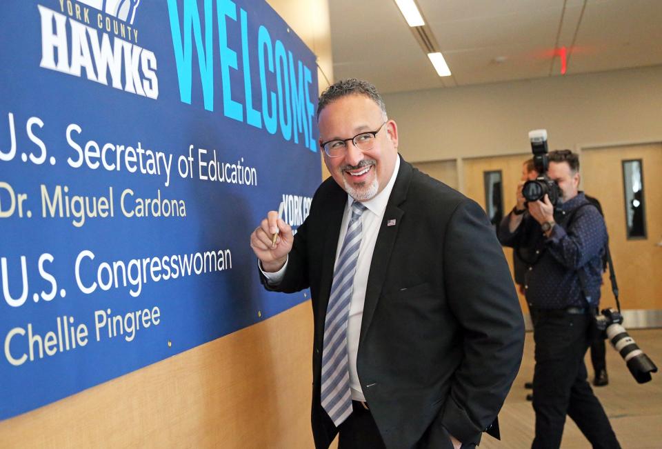 U.S. Secretary of Education Miguel Cardona signs a banner welcoming him and Congresswoman Chellie Pingree for a visit York County Community College April 11, 2022.