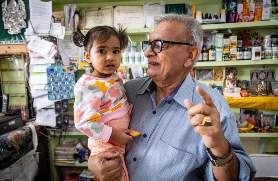 Suresh Sheth sostiene a su nieta Zohra Tankha-Sheth dentro de la Indo American Store en West Kendall. 'No está en su naturaleza sentarse y tomarse vacaciones', dice Alpen Sheth, el padre de Zohra.