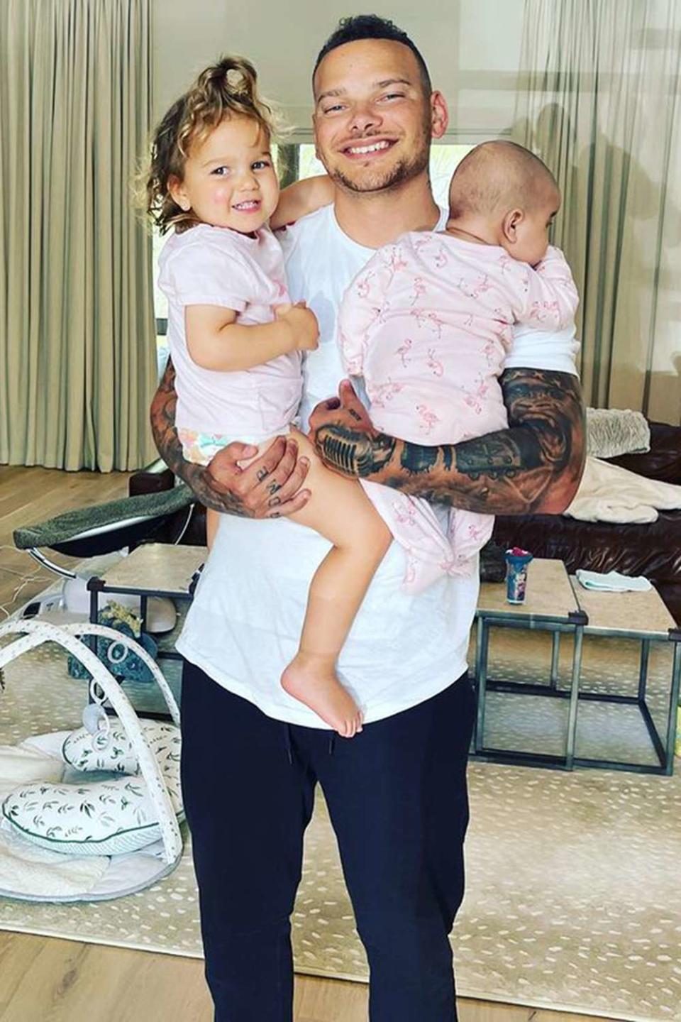 Kane Brown holding his children at home