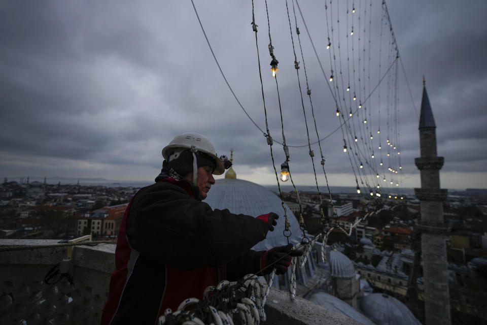 Mahya master Cemil Buyurkan works in the installation of a lights message at the top of one of the minarets of the Suleymaniye Mosque in Istanbul, Turkey, Wednesday, March 6, 2024. Mahya is the unique Turkish tradition of stringing religious messages and designs between minarets. (AP Photo/Emrah Gurel)