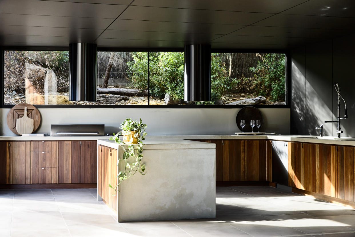  A kitchen designed in wood and concrete, with natural light pouring in. 