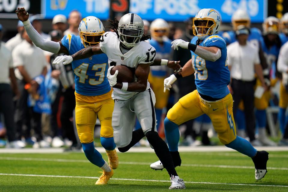 Las Vegas Raiders wide receiver Davante Adams (17) runs in front of Los Angeles Chargers cornerback Michael Davis (43) and linebacker Drue Tranquill during the first half of an NFL football game in Inglewood, Calif., Sunday, Sept. 11, 2022.