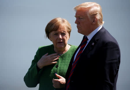 FILE PHOTO: Germany's Chancellor Angela Merkel talks with U.S. President Donald Trump during a family photo at the G7 Summit in Charlevoix, Quebec, Canada, June 8, 2018. REUTERS/Leah Millis/File Photo