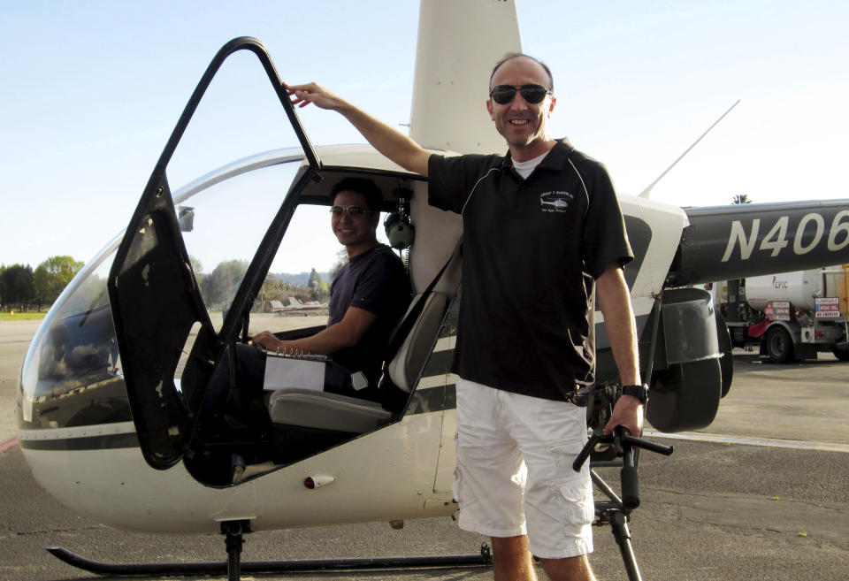 This undated photo provided by Group 3 Aviation shows helicopter pilot Ara Zobayan standing outside a helicopter, at a location not provided. Zobayan was at the controls of the helicopter that crashed in Southern California Sunday, Jan. 26, 2020, killing all nine aboard including former Lakers star Kobe Bryant. The other person inside is unidentified. (Group 3 Aviation via AP)