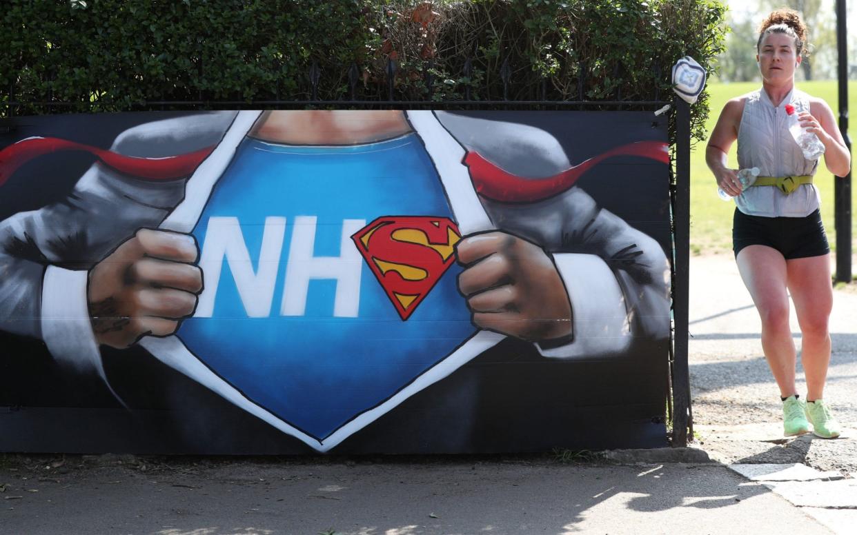 A runner passes street art in appreciation of the NHS in London - Jonathan Brady/PA Wire