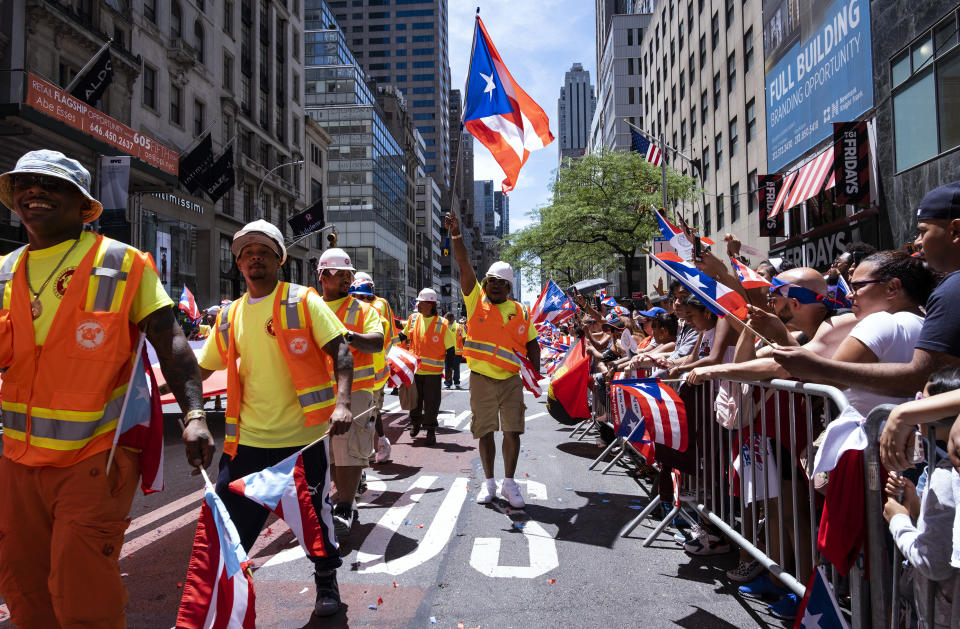 A parade unit walks along 5th Ave. during the National Puerto Rican Day Parade Sunday, June 9, 2019, in New York. (AP Photo/Craig Ruttle)