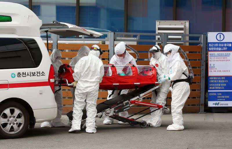 A confirmed coronavirus patient is wheeled to a hospital at Chuncheon