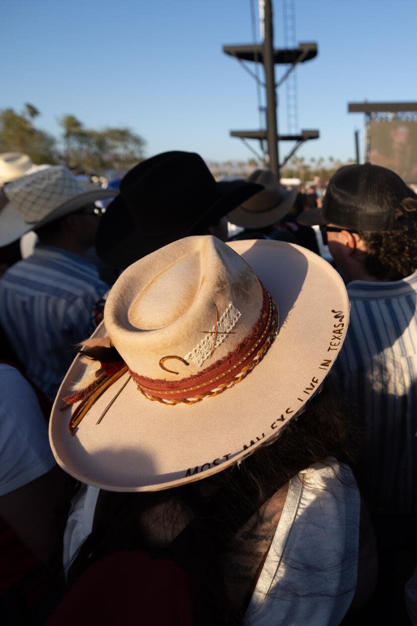 Two women sport country hats, one saying 