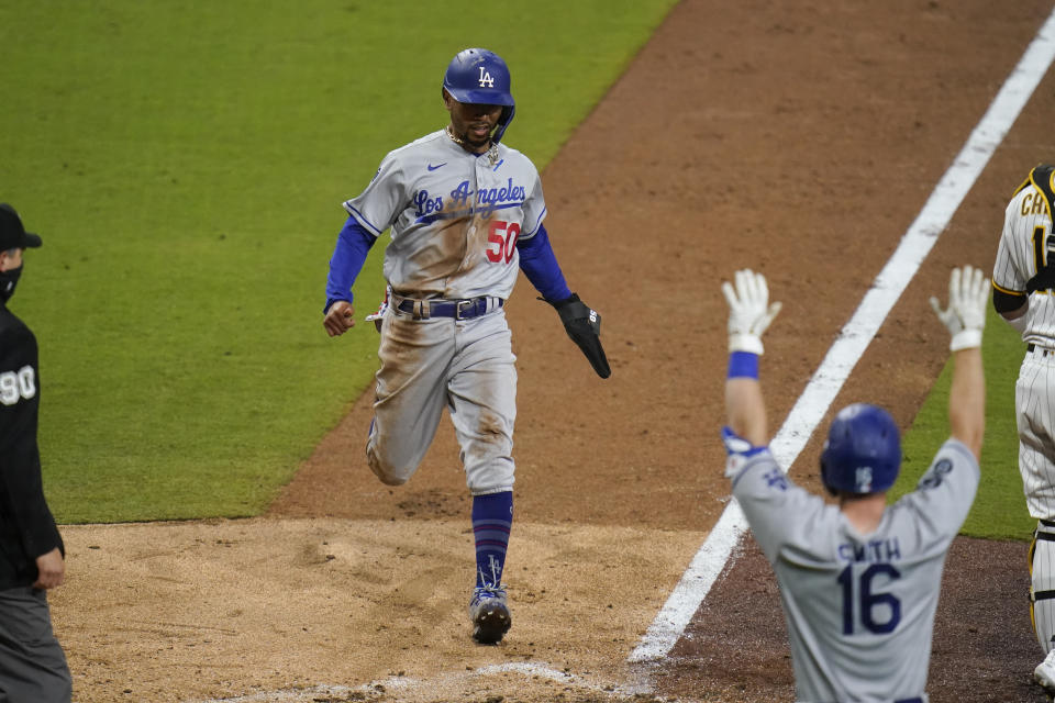 Los Angeles Dodgers' Mookie Betts scores on a single by Justin Turner during the ninth inning of the team's baseball game against the San Diego Padres, Friday, April 16, 2021, in San Diego. (AP Photo/Gregory Bull)