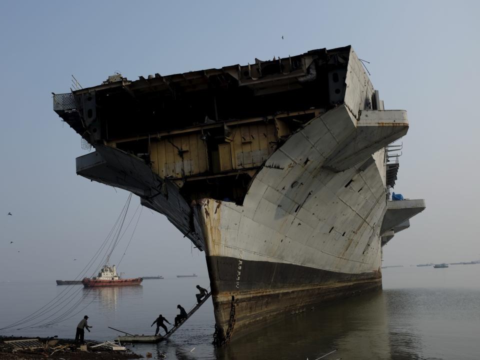 Workers climb down from decommissioned Indian Navy Ship INS Vikrant at a ship breaking yard in Mumbai Workers climb down from decommissioned Indian Navy Ship INS Vikrant at a ship breaking yard in Mumbai, India, November 24, 2014.