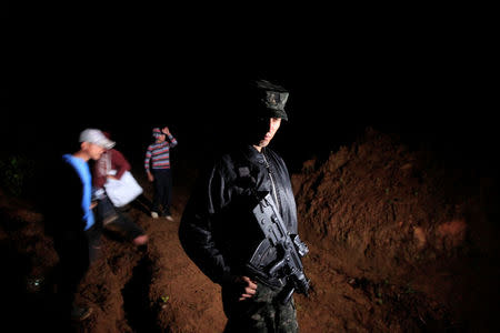 A Honduras soldier guards the area where Hilda Hernandez, the sister of Honduran President Juan Orlando Hernandez, and five others died when the helicopter they were traveling in crashed in San Matias, Honduras December 16, 2017. REUTERS/ Jorge Cabrera