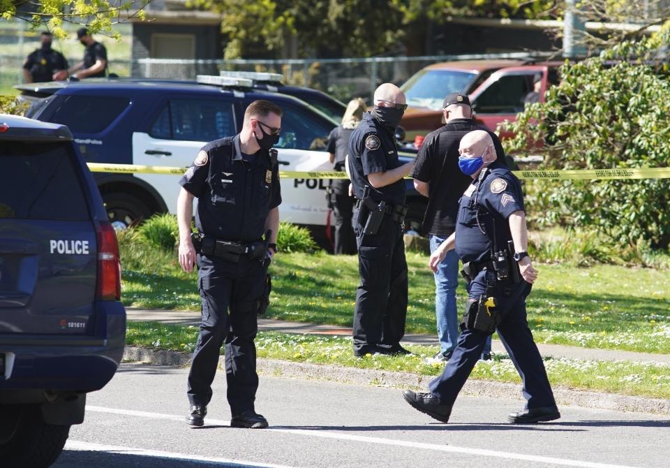 FILE - Law enforcement personnel work at the scene following a police-involved shooting of a man in Portland, Ore., on April 16, 2021. An Oregon lawmaker has introduced a bill that would require law enforcement officers complete at least two years of postsecondary education. The bill would push back against the recent trend of lowering police hiring standards by requiring two years of postsecondary education for departments with less than 50 officers and a bachelor's degree for departments with more than 50. (Beth Nakamura/The Oregonian via AP, File)