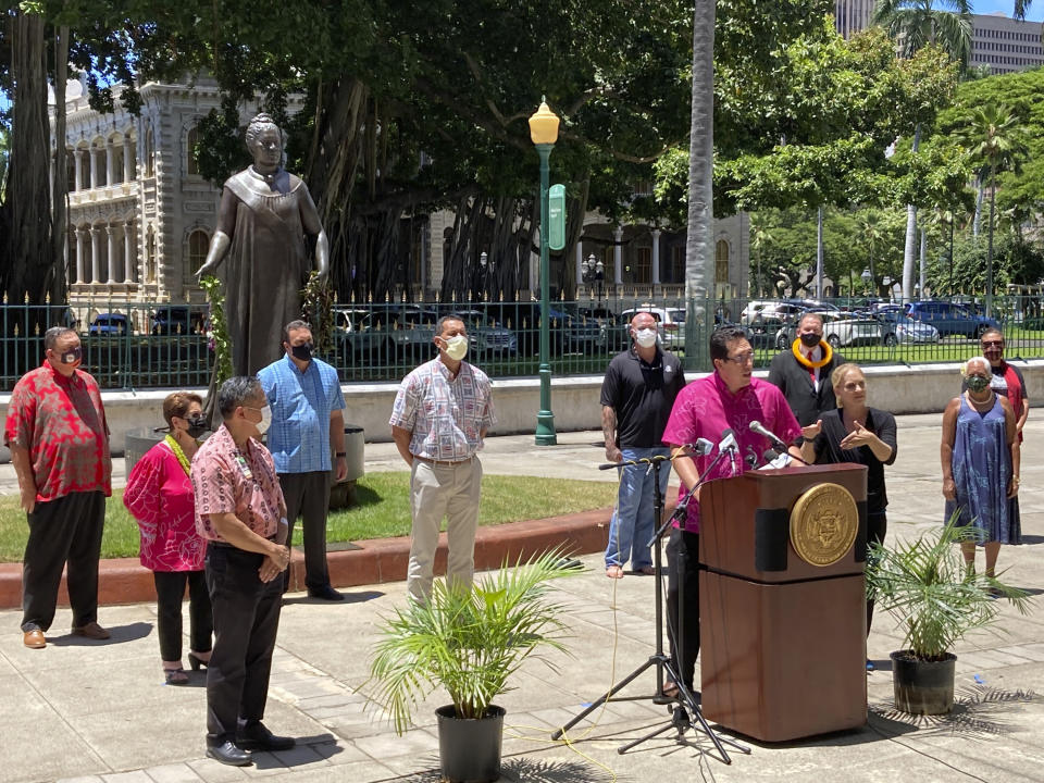 In this Thursday, Aug. 26, 2021, photo State Sen. Jarrett Keohokalole, at podium, speaks at a gathering of Native Hawaiian leaders urging Hawaiians to get vaccinated against COVID-19 and wear masks in Honolulu. Hawaii is experiencing a COVID-19 surge as hospitals are overflowing, vaccinations are stagnating and Hawaiians experiencing a disproportionate share of the suffering. (AP Photo/Jennifer Sinco Kelleher)