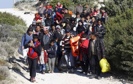 Turkish Gendarmes (in the background) lead a group of refugees to buses to prevent them from sailing off for the Greek island of Chios by dinghies, at a beach in the western Turkish coastal town of Cesme, in Izmir province, Turkey, in this November 5, 2015 file photo. REUTERS/Umit Bektas/Files