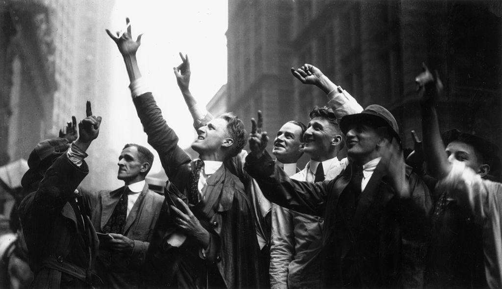 A black and white photo shows Curb Market traders gesture with their hands on Wall Street in NYC.