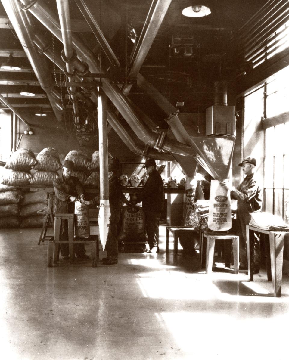 Ford workers in the charcoal briquets packaging factory in Kingsford, which sold to a local investor group in 1951. Charcoal was made with scrap wood from auto manufacturing.