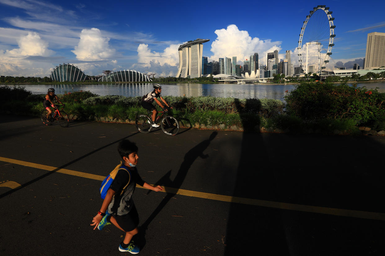 People jog and cycle along the Singapore bay front.