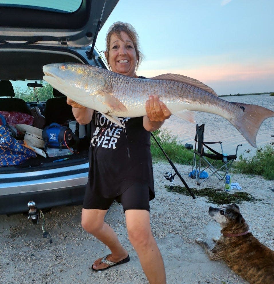 Kelly Weikman shows off a yard-long red that quickly went back in the river. She was fishing from shore near the Mosquito Lagoon Bait & Tackle down the road in Brevard County.