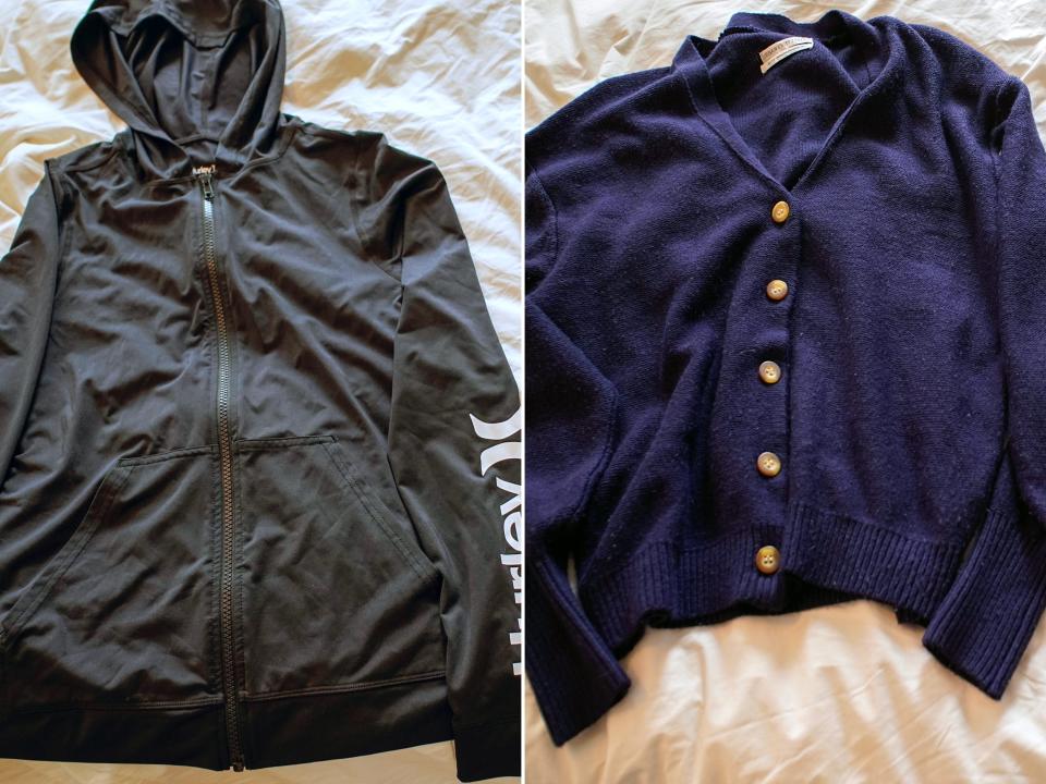 Left image: A black zipped hoodie lays on a white sheet. Right image: A navy blue buttoned cardigan lays on a white sheet.