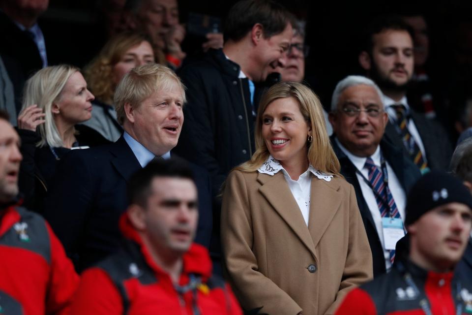 Britain's Prime Minister Boris Johnson (L) with his partner Carrie Symonds attend the Six Nations international rugby union match between England and Wales at the Twickenham, west London, on March 7, 2020. (Photo by Adrian DENNIS / AFP) (Photo by ADRIAN DENNIS/AFP via Getty Images)