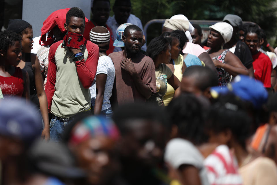 People wait in line during a federal government distribution of food and school supplies at the mayor's office in Cite Soleil, Port-au-Prince, Haiti, Thursday, Oct. 3, 2019. The administration of President Jovenel Moise tried to alleviate Haiti’s economic crunch on Thursday by distributing plates of rice and beans, sacks of rice, and school backpacks filled with four notebooks and two pens. (AP Photo/Rebecca Blackwell)