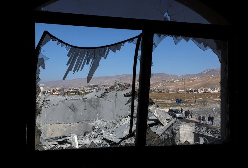 People gather near a damaged site that was hit by a strike, in Douris