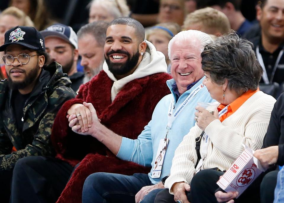 Drake, shown attending a basketball game, is no longer part of the 2022 Grammy Awards.