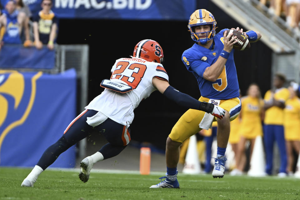 Pittsburgh quarterback Kedon Slovis (9) eludes Syracuse defensive back Justin Barron (23) during the first half of an NCAA college football game, Saturday, Nov. 5, 2022, in Pittsburgh. (AP Photo/Barry Reeger)