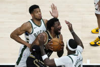 Atlanta Hawks forward Solomon Hill (18) drives between Milwaukee Bucks' Giannis Antetokounmpo, left, and Bobby Portis (9) during the first half of an NBA basketball game Thursday, April 15, 2021, in Atlanta. (AP Photo/John Bazemore)