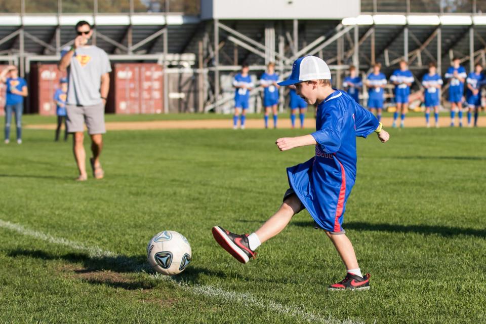 Honorary Winnacunnet High School boys soccer captain Evan Austin lines up and kicks the ball in the net during opening ceremonies prior to last October's game against Londonderry.