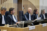 Presiding judge Hendrik Steenhuis, center, opens the court session as the trial resumed at the high security court building at Schiphol Airport, near Amsterdam, Monday, June 8, 2020, for three Russians and a Ukrainian charged with crimes including murder for their alleged roles in the shooting down of Malaysia Airlines Flight MH17 over eastern Ukraine nearly six years ago. (AP Photo/Robin van Lonkhuijsen, POOL)