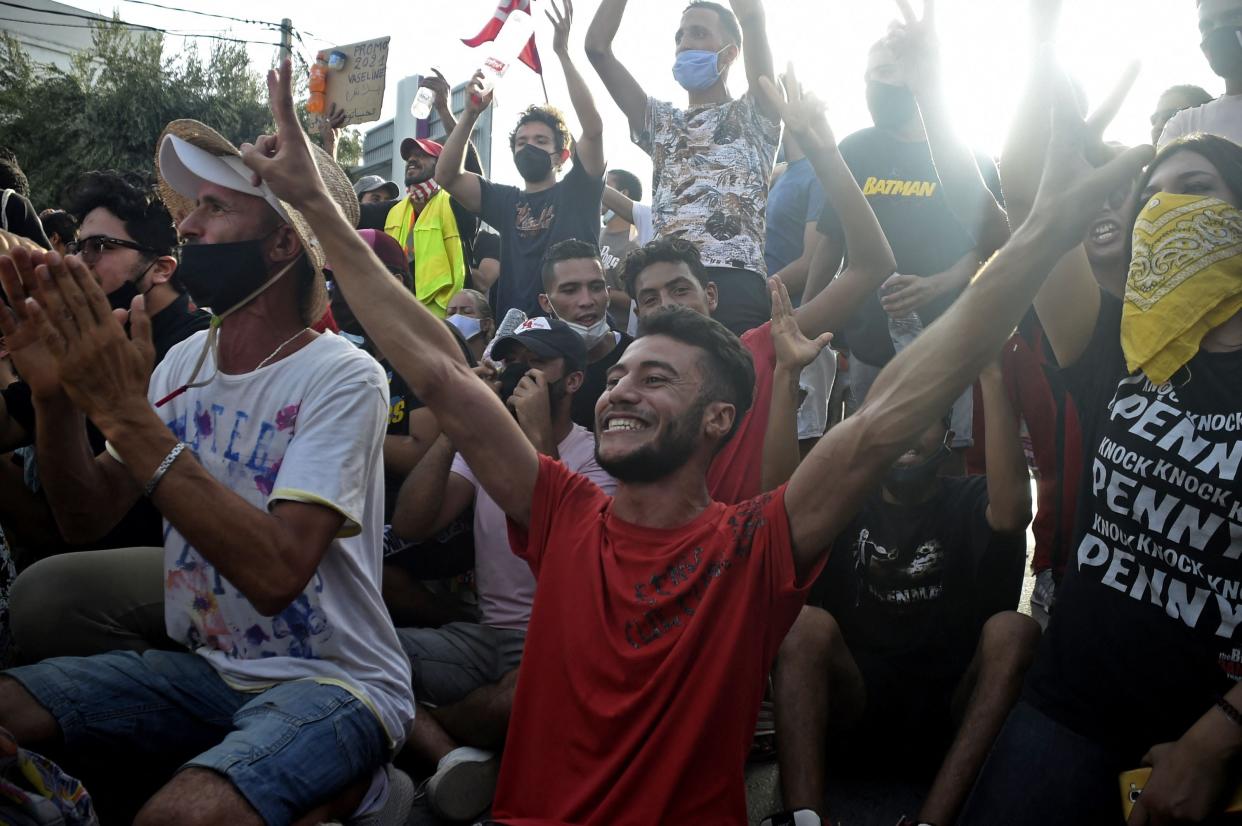 Supporters cheer outside parliament in Tunis after the president dismissed the prime minister  (AFP via Getty Images)