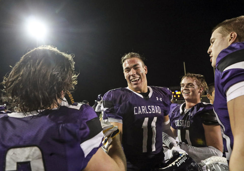 Carlsbad's Zachary Marshall (11) and teammates celebrate beating Poway after their Open Division playoff high school football game on Thursday, Nov. 10, 2022 in Carlsbad, Calif. Marshall, a tight end from Carlsbad (California) High School, committed to Michigan in mid-August but said the news about USC and UCLA didn’t impact his decision. The addition of USC and UCLA to the Big Ten increases the likelihood he’d play at least one game in his home state. (Meg McLaughlin/The San Diego Union-Tribune via AP)