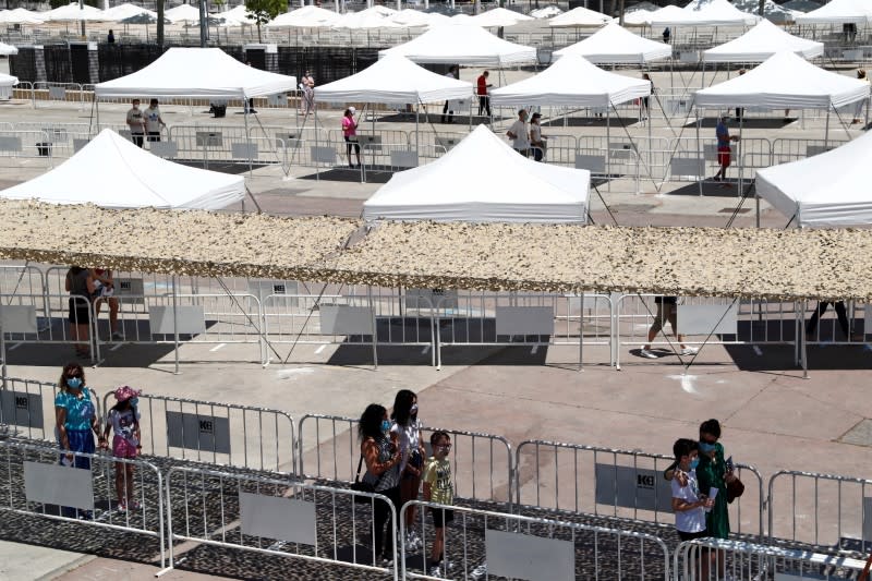 FILE PHOOT: People queue maintaining social distancing as they volunteer to be tested at a temporary testing station where the city council is providing free tests for the coronavirus disease (COVID-19) to residents, in Torrejon de Ardoz