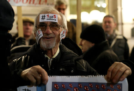 A demonstrator holds a placard during a protest against Serbian President Aleksandar Vucic and his government in central Belgrade, Serbia, January 12, 2019. REUTERS/Djordje Kojadinovic