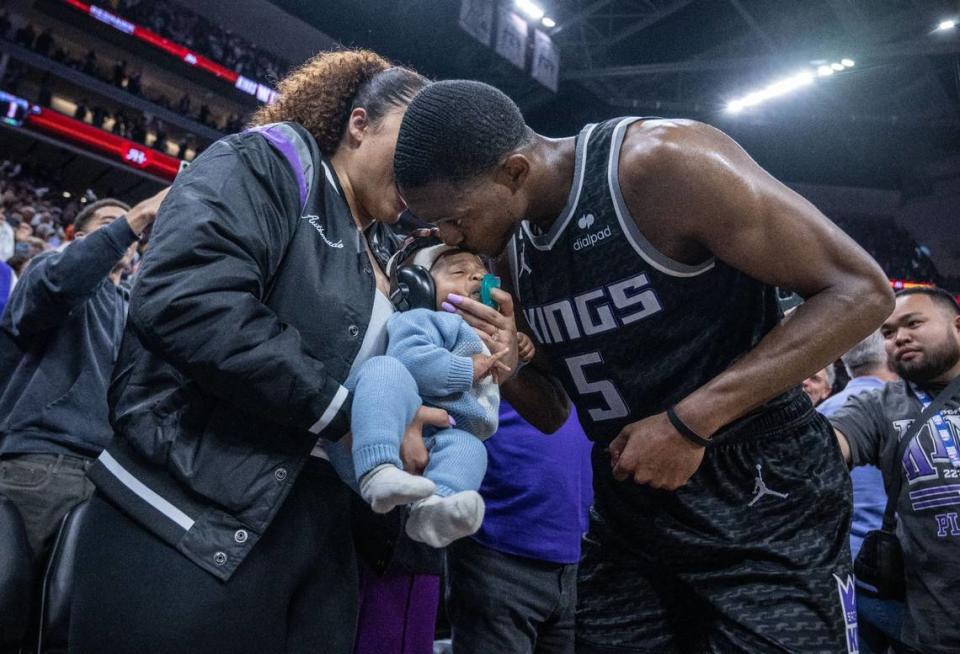 Sacramento Kings guard De’Aaron Fox (5) kisses his son Reign (held by his mother, Recee Caldwell) after the team’s Game 2 win in a first-round NBA playoff series against the Golden State Warriors on April 17.
