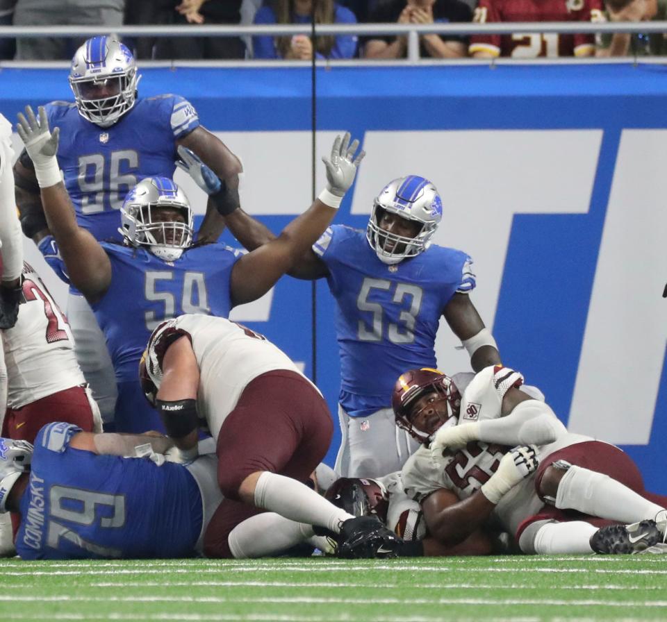 Detroit Lions defensive tackle Alim McNeill (54) and linebacker Charles Harris (53) celebrate a stop at the goal line against the Washington Commanders during the second half at Ford Field, Sept. 18, 2022.