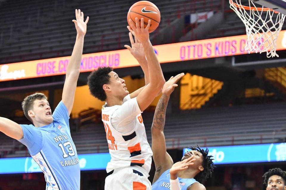 Syracuse Orange center Jesse Edwards (14) shoots near the basket as North Carolina Tar Heels forward Walker Kessler (13) and guard Caleb Love (bottom) defend in the first half at the Carrier Dome.