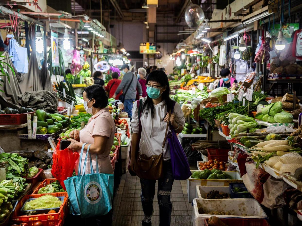 Shoppers at a wet market in Hong Kong on February 25, 2020 (Photo by ISAAC LAWRENCE/AFP via Getty Images): Getty