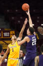 Northwestern's Pete Nance (22) shoots over Minnesota's Tre' Williams (1) in the first half of an NCAA college basketball game, Thursday, Feb. 25, 2021, in Minneapolis. (AP Photo/Jim Mone)