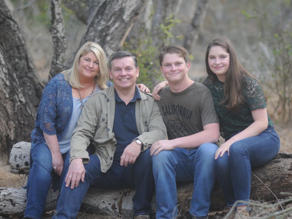 The Cantin family poses for a family photograph on a log