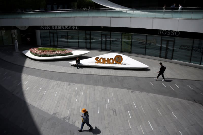 FILE PHOTO: People wearing face masks are seen at the Galaxy Soho office buildings in Beijing