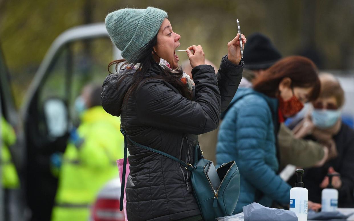 People take part in coronavirus surge testing on Clapham Common, south London. Thousands of residents have queued up to take coronavirus tests at additional facilities set up after new cases of the South African variant were found in two south London boroughs. 44 confirmed cases of the variant have been found in Lambeth and Wandsworth, with a further 30 probable cases identified - PA