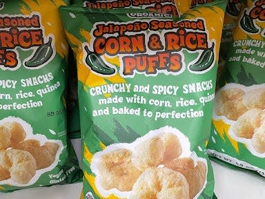 bags of trader joe's spicy corn and rice puffs on the shelves