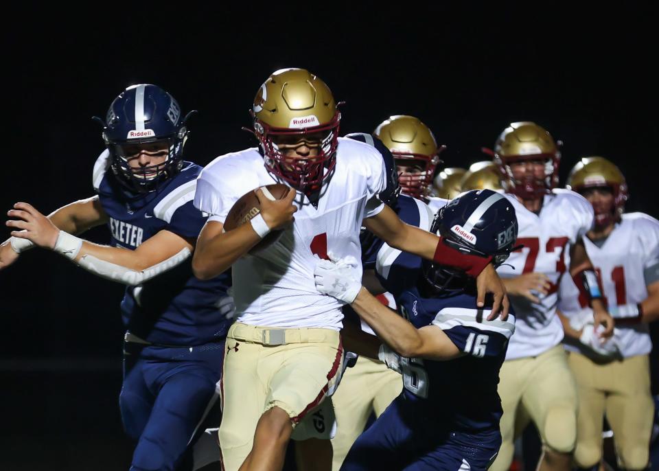 Portsmouth quarterback Aidan Thomas runs with the football as Exeter's Sean DeLello (16) gets a hold of his jersey during Friday's season opener.