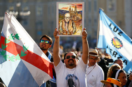 A faithful holds a painting of Giuseppe Gabriele Del Rosario Brochero, one of the new seven saints, before the start of a canonization mass led by Pope Francis in Saint Peter's Square at the Vatican October 16, 2016. REUTERS/Tony Gentile