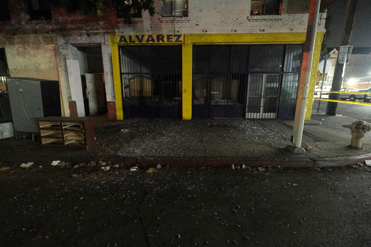 Local business are seen damaged after illegal fireworks seized at a South Los Angeles home exploded, in South Los Angeles Wednesday evening, June 30, 2021. A cache of homemade fireworks exploded as it was being destroyed by a bomb squad, flipping and damaging cars, smashing windows in homes and injuring a dozen of people including police officers, authorities said. (AP Photo/Ringo H.W. Chiu)