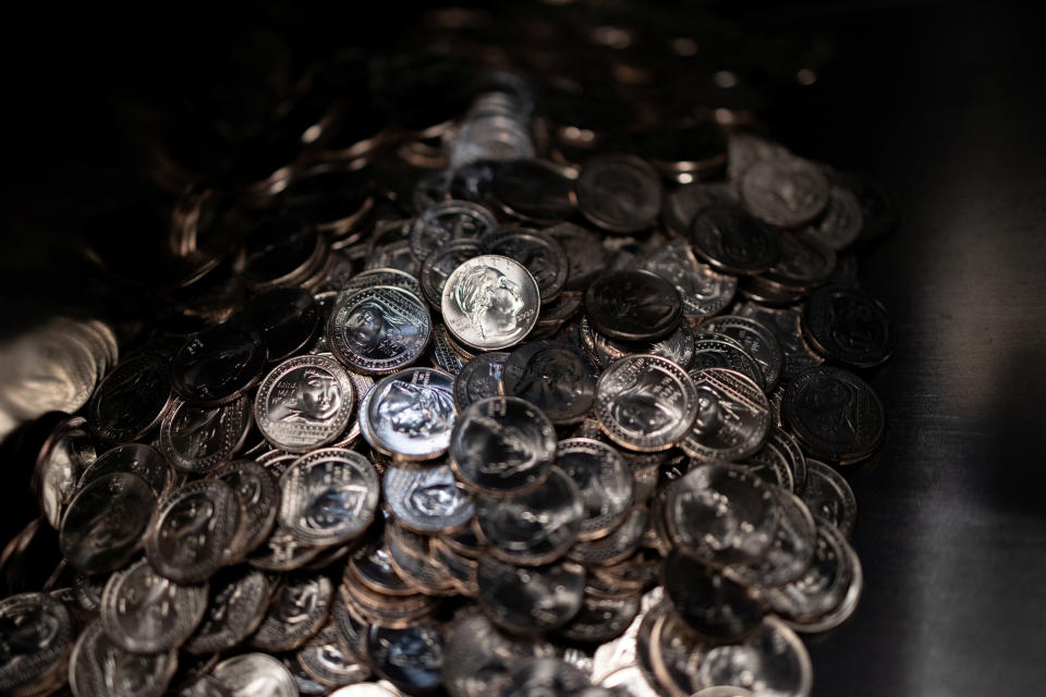 Quarter dollars that are cast with the likeness of Asian American actress Anna May Wong, the fifth 25-cent coin in the American Women Quarters (AWQ) Program to be issued by the U.S. Mint, exit the press into a trap to be inspected in Philadelphia, Pennsylvania, U.S. October 25, 2022. REUTERS/Hannah Beier