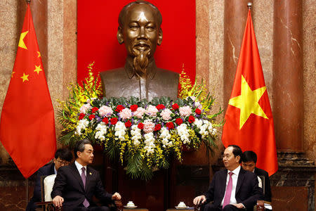 China's State Councilor and Foreign Minister Wang Yi and Vietnam's President Tran Dai Quang talk under a statue of the late Vietnamese revolutionary leader Ho Chi Minh at the Presidential Palace in Hanoi, Vietnam April 1, 2018. REUTERS/Kham